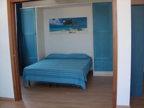 San SabaAppartamenti Sole Mare - Affitto minimo settimanale - Weekly minimum rent的一间卧室配有一张蓝色的床铺和镜子