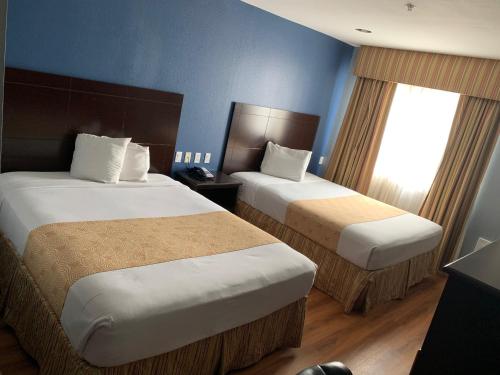 亚瑟港Rodeway Inn & Suites Port Arthur - Groves的酒店客房设有两张床和窗户。