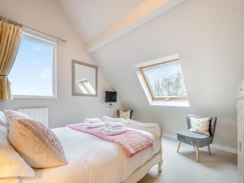 贝克因顿Pears Cottage - Uk43674的一间卧室设有一张床、一个窗口和一把椅子
