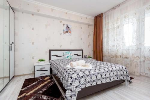 阿拉木图Светлая квартира рядом с парком Горького的一间卧室配有一张带黑白色床罩的床。