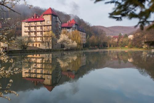 波利亚纳Ruta Resort Polyana的湖中建筑物的反射