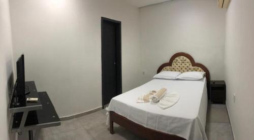 库亚巴Hotel Cuiabá的一间卧室配有一张床,上面有两条毛巾