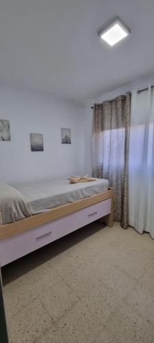 大加那利岛拉斯帕尔马斯vivienda Acerina的一间卧室设有一张床和一个窗口