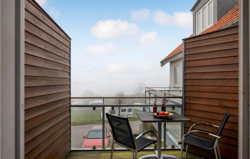 古兹耶姆Lovely Apartment In Gudhjem With Wifi的阳台配有桌椅,享有汽车的景致。