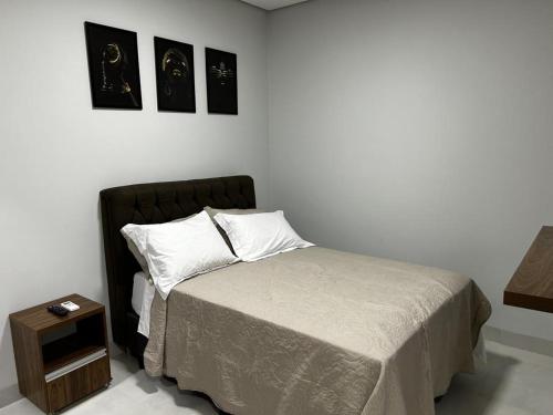 锡诺普Aquarela Apart Hotel的卧室配有一张床,墙上挂有两张照片