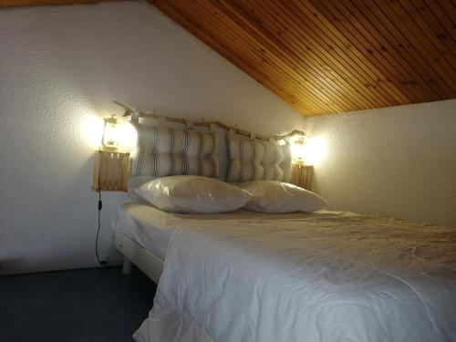 莱马特Maison à La Palmyre, proche commerces et plages的一间卧室配有一张带两个灯的床