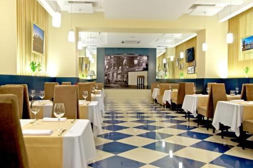 扎波罗热Teatralny Hotel的一间带桌椅和 ⁇ 制地板的餐厅
