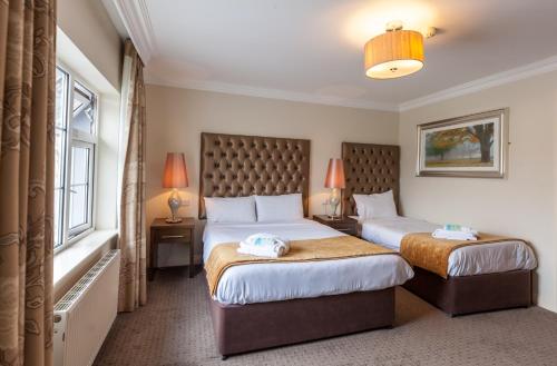 基拉尼城堡旅舍的酒店客房设有两张床和窗户。