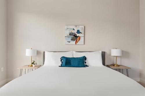 丹佛Kasa RiNo Denver的一间卧室配有一张带两盏灯的大型白色床。