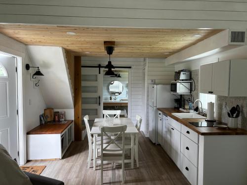 霍姆斯泰德Maria's Tiny Barn的厨房配有白色橱柜和桌椅