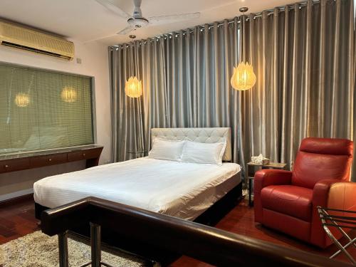 达卡海特当代公寓酒店的一间卧室配有一张床和一张红色椅子
