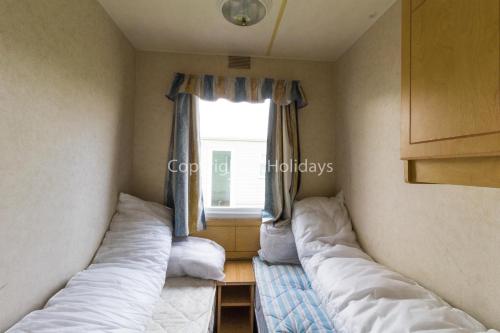 大雅茅斯8 Berth Caravan At California Cliffs Holiday Park In Norfolk Ref 50007d的小型客房 - 带2张床和窗户