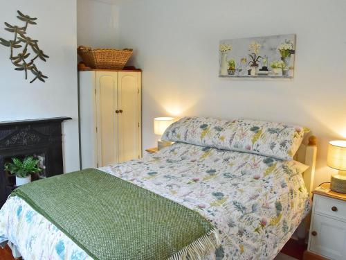 Bardon MillFern Cottage的一间卧室配有一张带绿色棉被的床