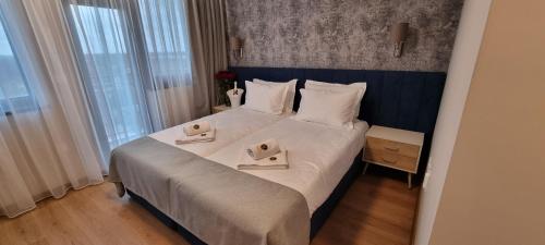 Gorni DŭbnikPark Hotel Viasport的一间卧室配有一张大床和两条毛巾