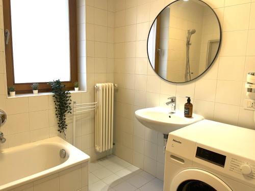 梅拉诺Kurhaus Apartment + parking的一间带水槽和洗衣机的浴室