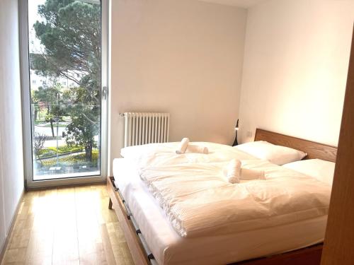 梅拉诺Kurhaus Apartment + parking的一间卧室设有两张床和大窗户