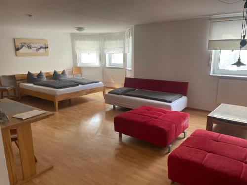 卡佩尔-格拉芬豪森Lissi Apartment nur 5 Min vom Europa Park und direkt am Naturschutzgebiet的客厅配有两张床和一张红色沙发