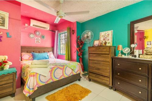 蒙特哥贝Colorful Private Room Oasis的色彩缤纷的卧室设有床和水槽
