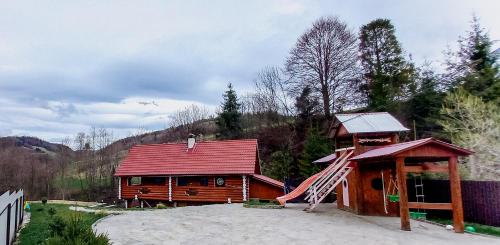 HuklyvyyКотедж в Карпатах的小木屋设有红色屋顶和楼梯