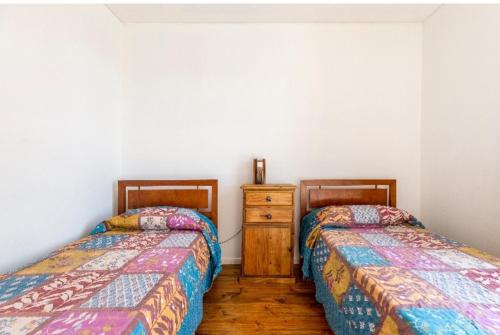 门多萨Mendoza San Isidro Cabaña的两张睡床彼此相邻,位于一个房间里