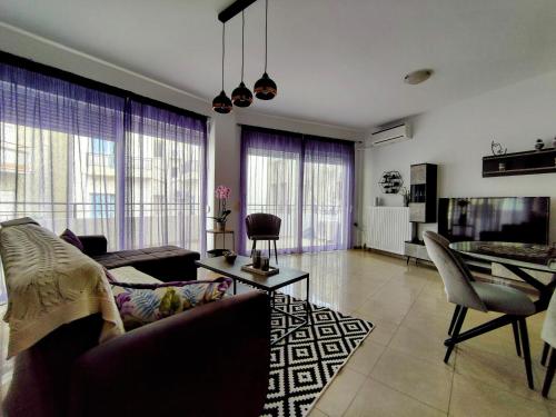 海若克利欧Central Purple Spot的带沙发和电视的客厅