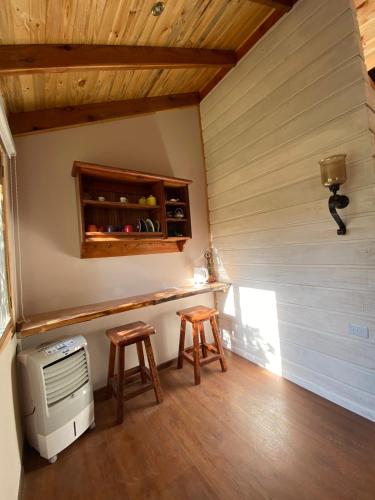 MaipoLoft Cabaña El Recuerdo的一个小房间,配有炉灶和两个凳子