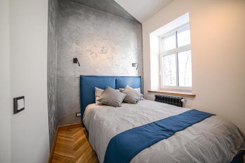 里加Homly S22的一间卧室设有蓝色的床和窗户。
