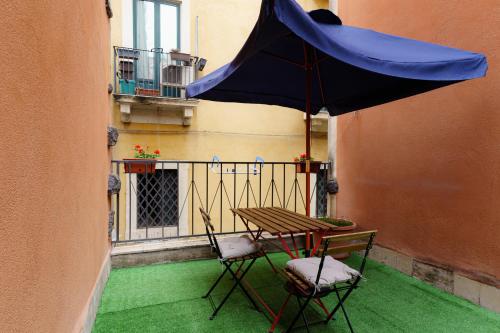 卡塔尼亚Casta Diva Holiday Rooms的阳台配有桌椅和遮阳伞