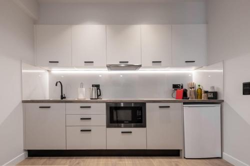 雅典A&N Athens Luxury Apartments - Ermou的厨房配有白色橱柜和微波炉