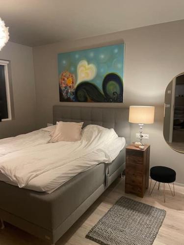 NjarðvíkBeautiful apartment near Airport的卧室配有一张床,墙上挂有绘画作品
