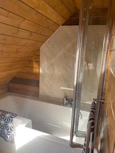 贝克斯利Little Barn ideal for short stays的带浴缸的浴室和木制天花板