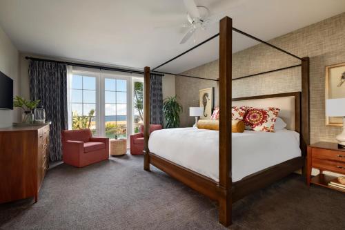 兰乔帕洛斯弗迪斯Terranea Resort的一间卧室配有一张天蓬床和一把椅子