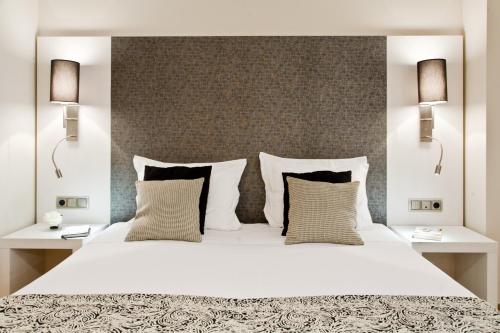 巴塞罗那Up Suites BCN的一间卧室配有一张带两盏灯的大型白色床。