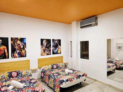 塞维利亚Arc House Plaza的一间设有两张床和墙上海报的房间