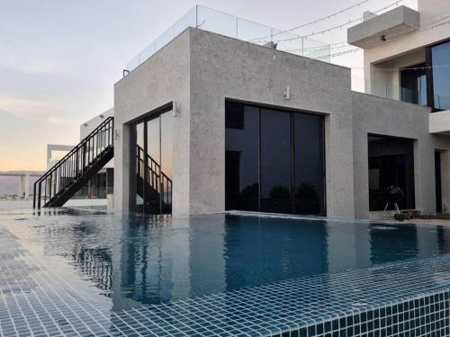FinsWadi Shab/Fins Villa的一座房子,旁边设有游泳池