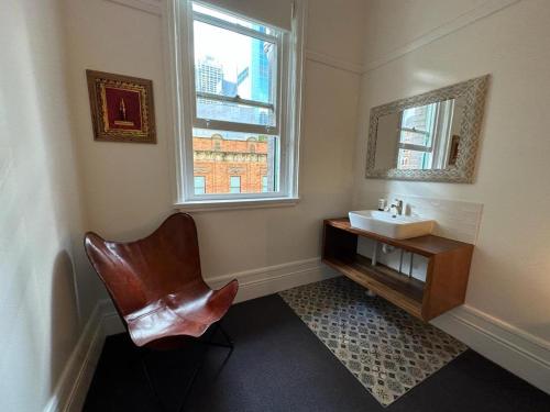 悉尼The Resch House的浴室设有水槽、椅子和镜子