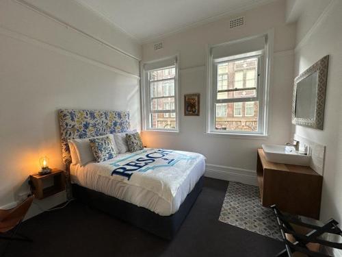 悉尼The Resch House的一间卧室配有床、水槽和2个窗户