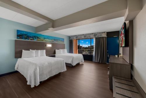 弗吉尼亚海滩Red Roof PLUS & Suites Virginia Beach - Seaside的酒店客房设有两张床和电视。