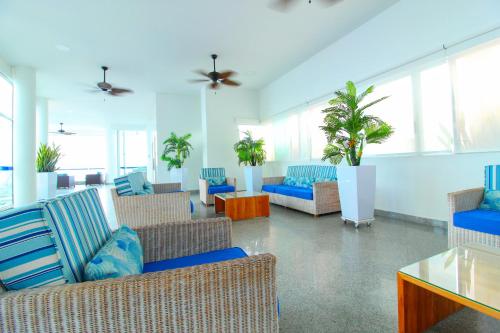 卡塔赫纳Apartamentos Palmetto - Frente al Mar的带沙发、椅子和植物的客厅