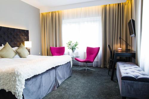 Knivsta诺瓦帕克康弗里斯酒店的酒店客房带一张床、一张桌子和椅子