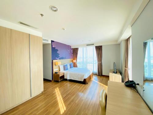 雅加达Habitare Apart Hotel Rasuna Jakarta Powered by Archipelago的酒店客房,配有床和电视