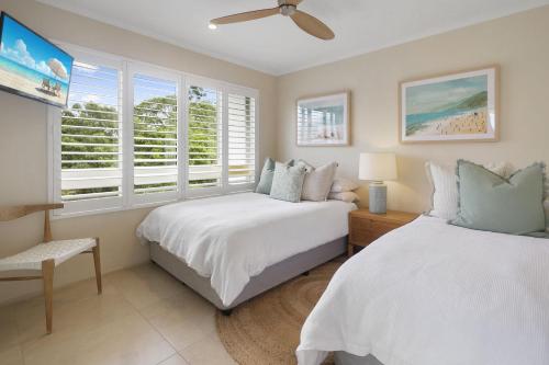 努萨角Serenity on Hastings Street, Noosa Heads的一间卧室设有两张床和窗户。