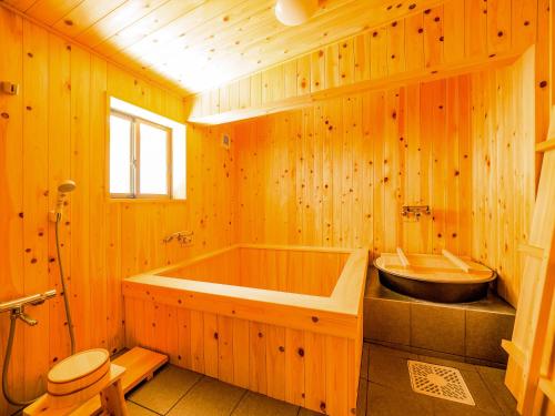 长滨市Chikubu Yuuan的木制浴室设有浴缸和水槽