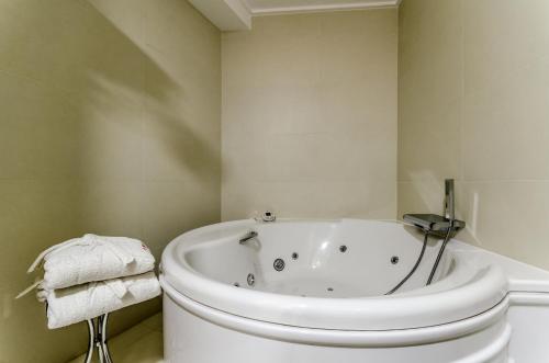 奥伦塞公主酒店的白色的浴室设有浴缸和卫生间。