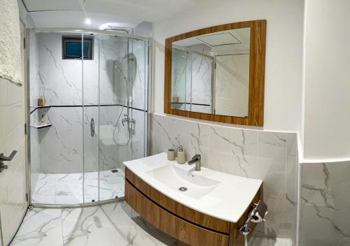 马累Tourist Inn Grand的带淋浴、盥洗盆和镜子的浴室