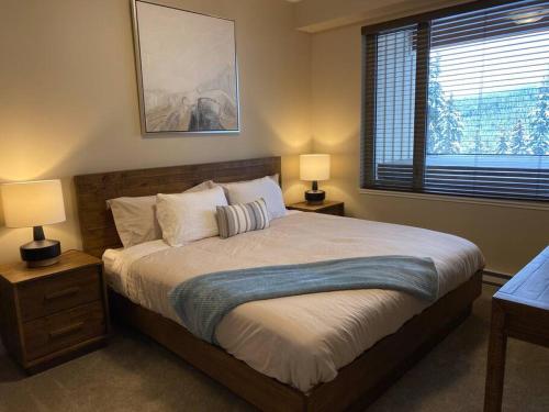 太阳峰Cozy Modern Ski-in/Ski-out, Hot Tub, Alpine Home的一间卧室配有一张带两盏灯的床和一扇窗户。