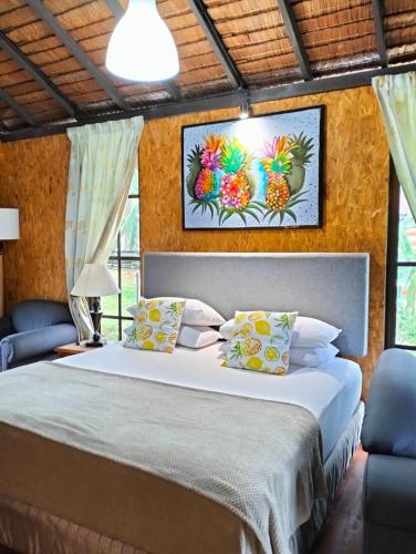 Kampong SenawarCHALET JOSAPINE D' RUMAH BONDA RIVER VIEW的一间卧室配有一张大床和两张蓝色椅子