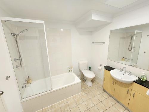 阿德莱德Spacious 4 BR and 2 Bathrooms City Apartment的带浴缸、卫生间和盥洗盆的浴室
