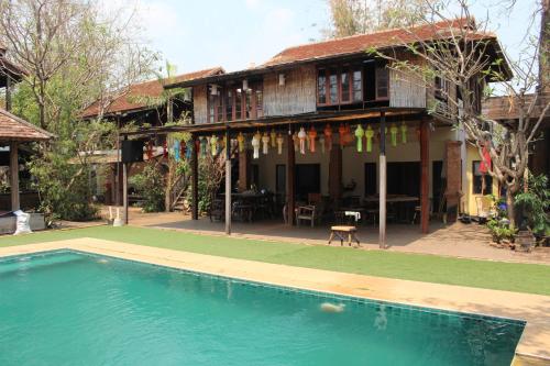 清迈Capital O 75421 Baan Singkham Boutique Resort的房屋前有游泳池的房子