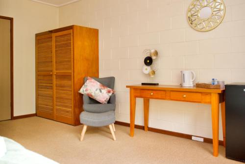 沃伯顿Green Gables Warburton - King Garden Suite的一间卧室配有书桌、椅子和桌子